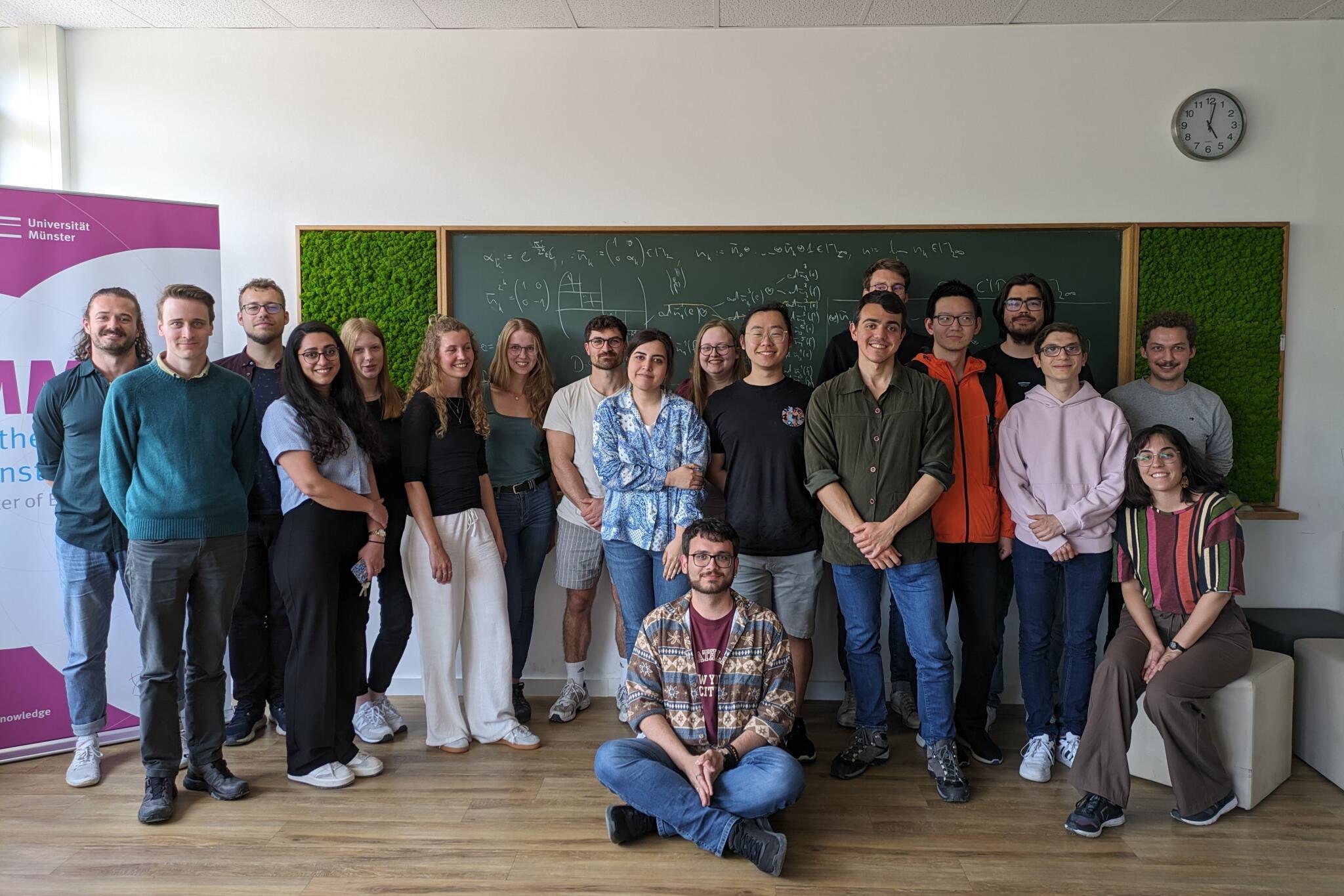 Picture of PhD students in front of a board from the Welcome Event of the Graduate School.